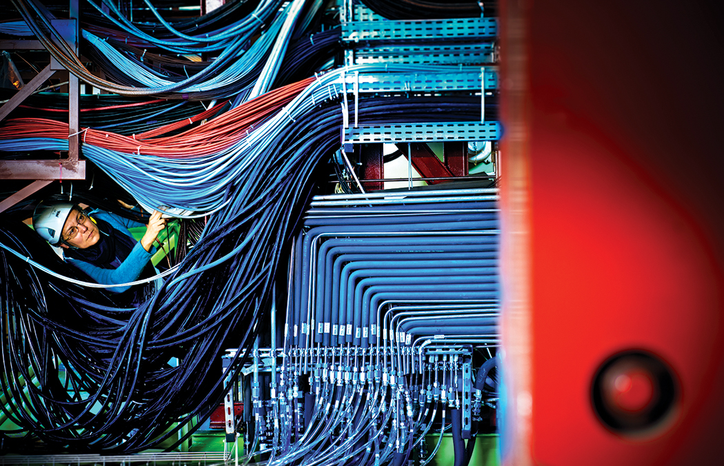 Physicist Despina Hatzifotiadou navigates a maze of color-coded wires at the ALICE detector, one of six detectors at the LHC