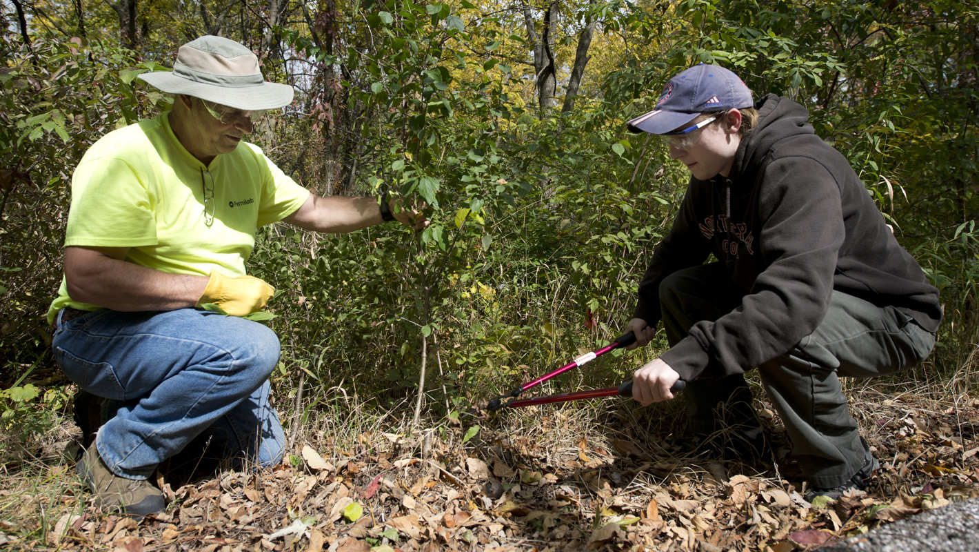 Photo of two men cleaning up river bank
