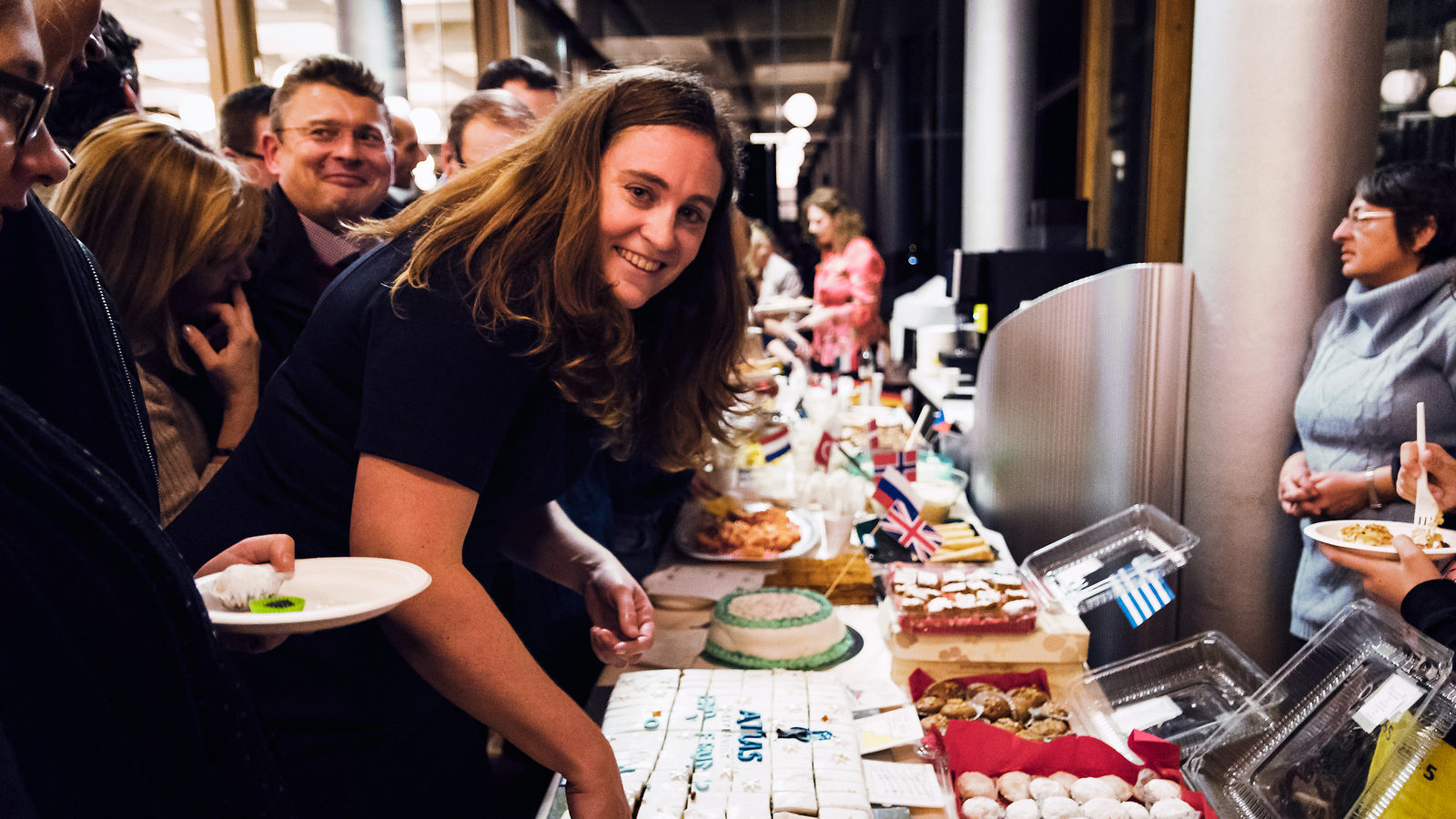 Photo of people picking up pieces of cake from a table