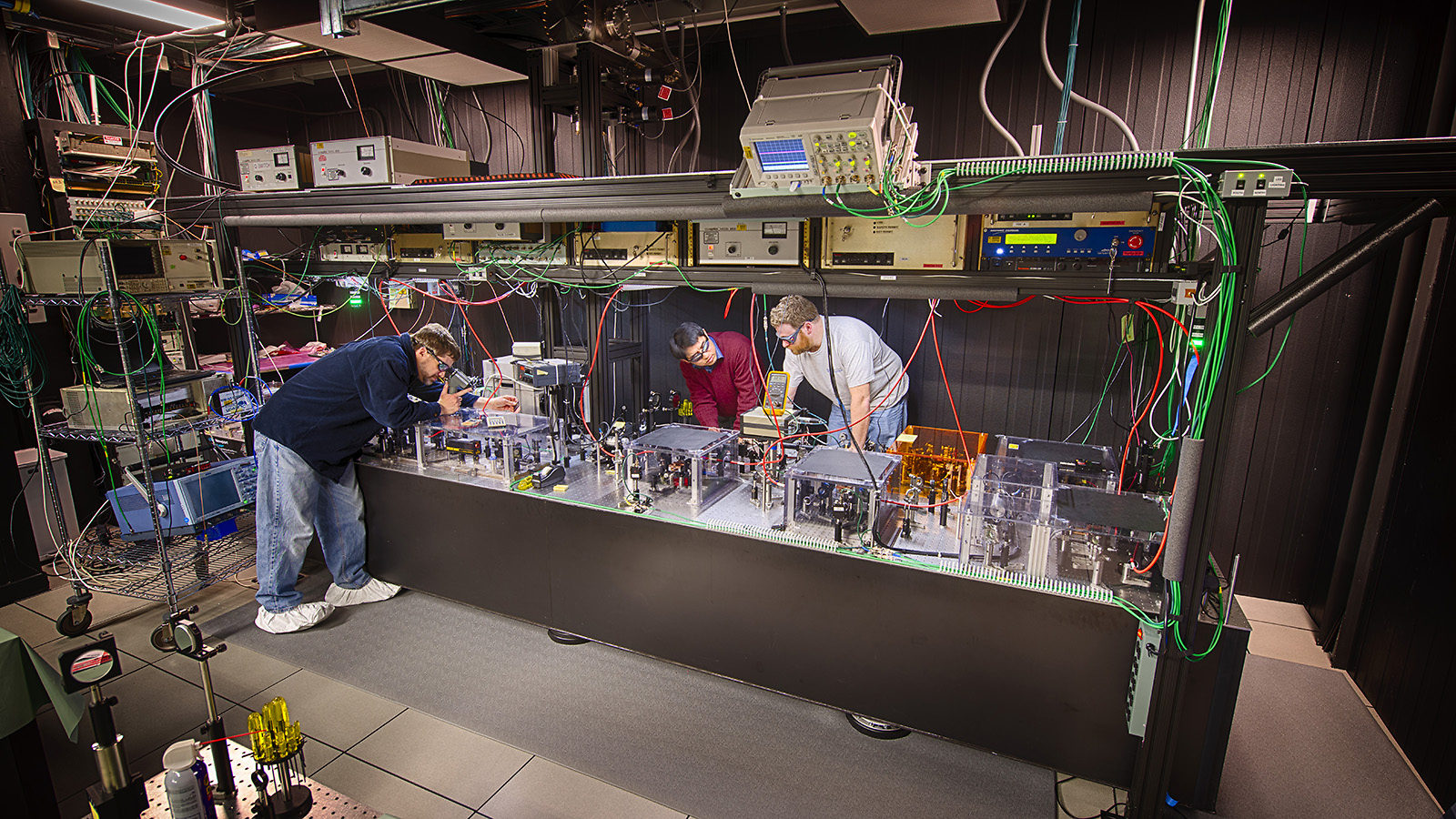 Scientists in laser safety goggles work in a laser lab