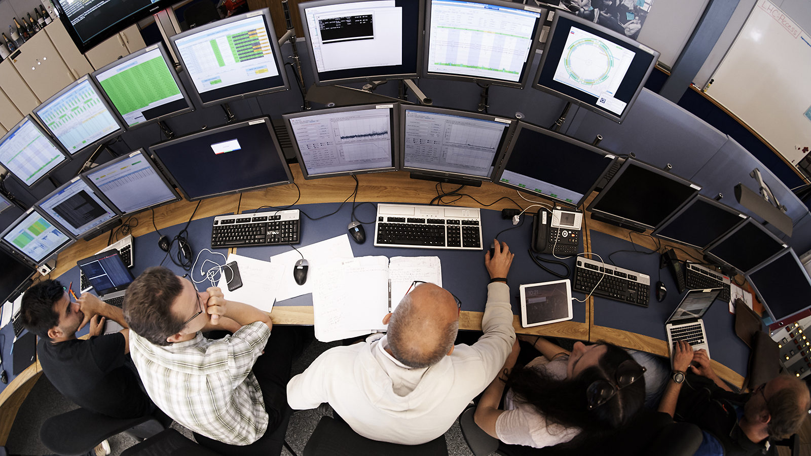 Overhead view of people sitting in front of two rows of computer screens