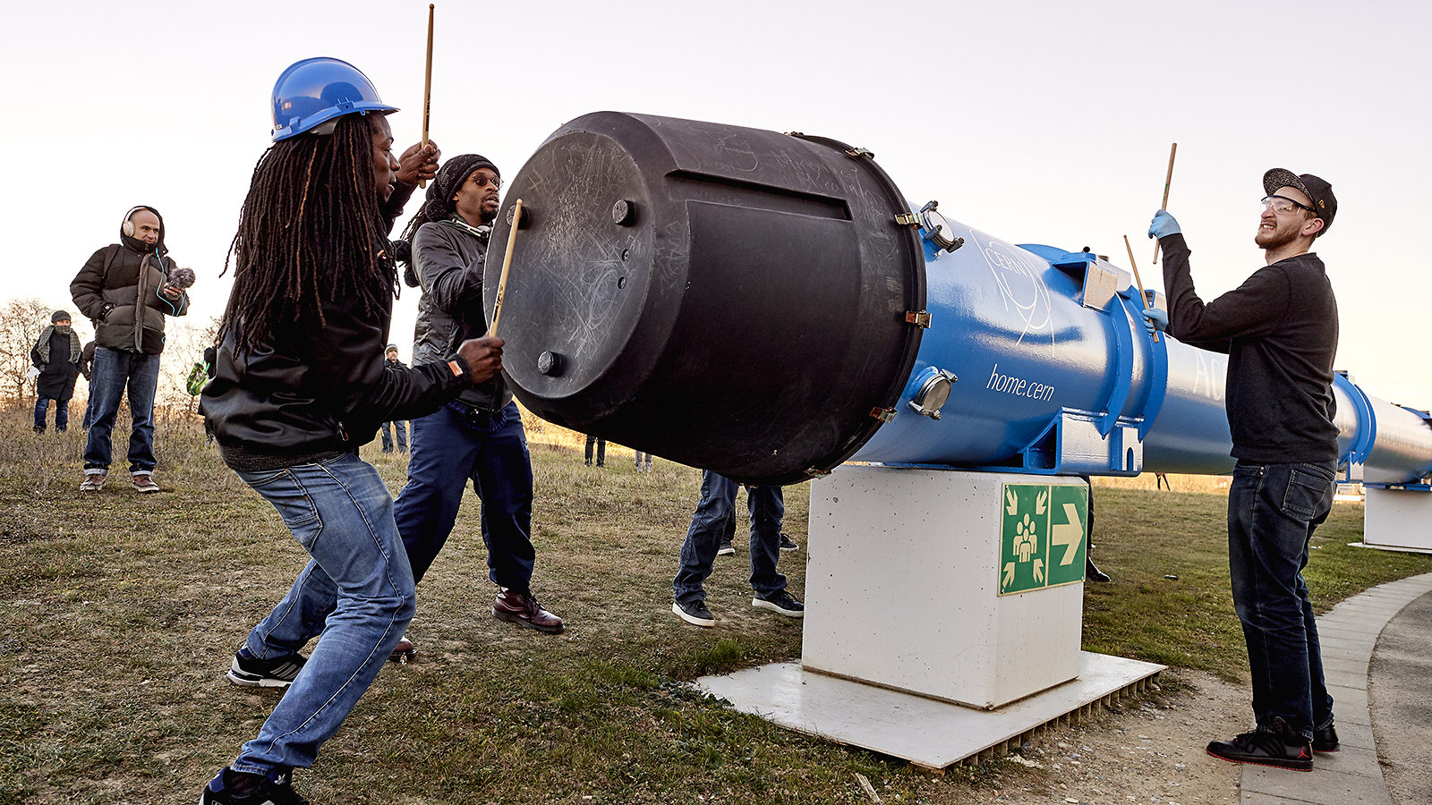 STOMP performers drum on a retired LHC cavity