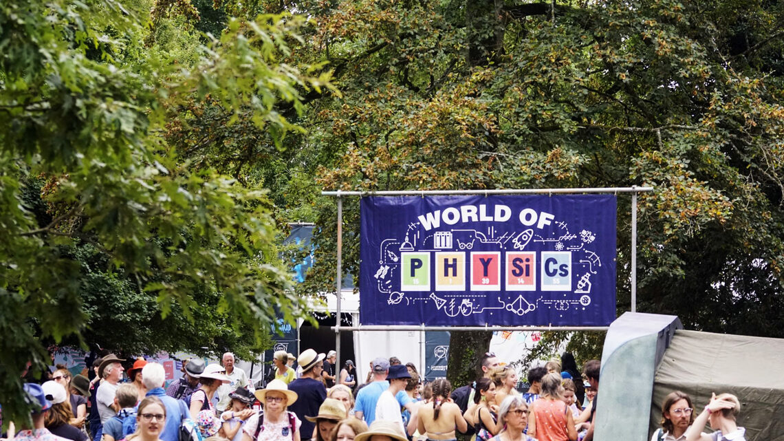 Wold of Physics sign amid crowd