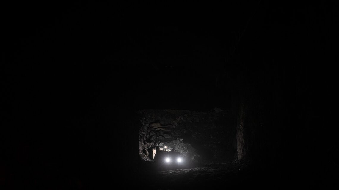Small points of light from equipment in a dark cavern
