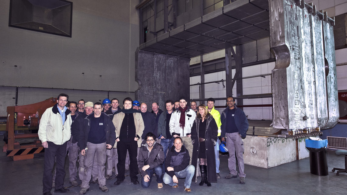 Team members in front of the magnet coils