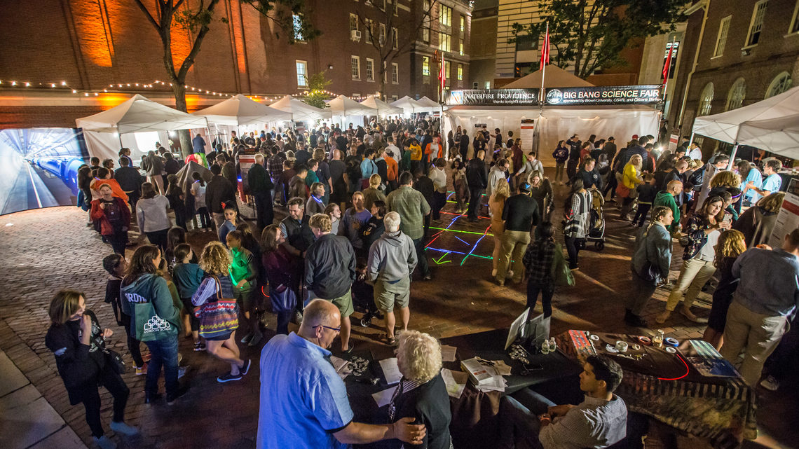 Aerial view of attendees walking between various stalls and booths, interacting and taking part