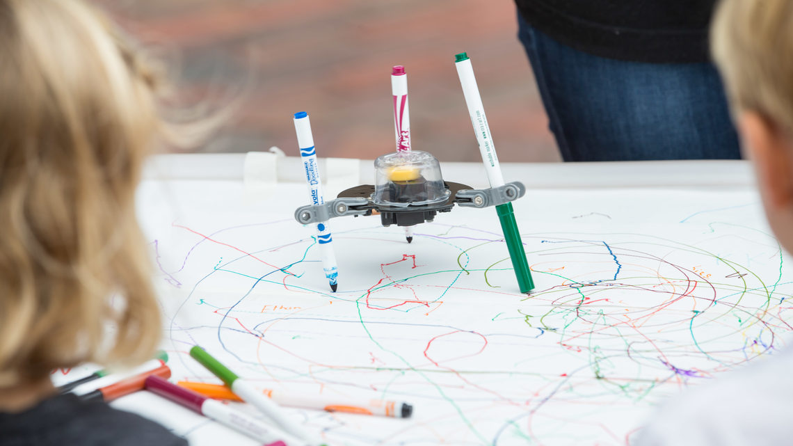 Kids taking part in a STEAM activity called "creating your own colored top”