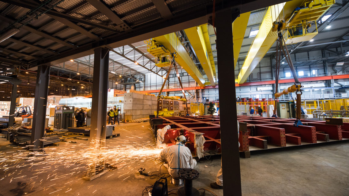 A welder works on a steel cage