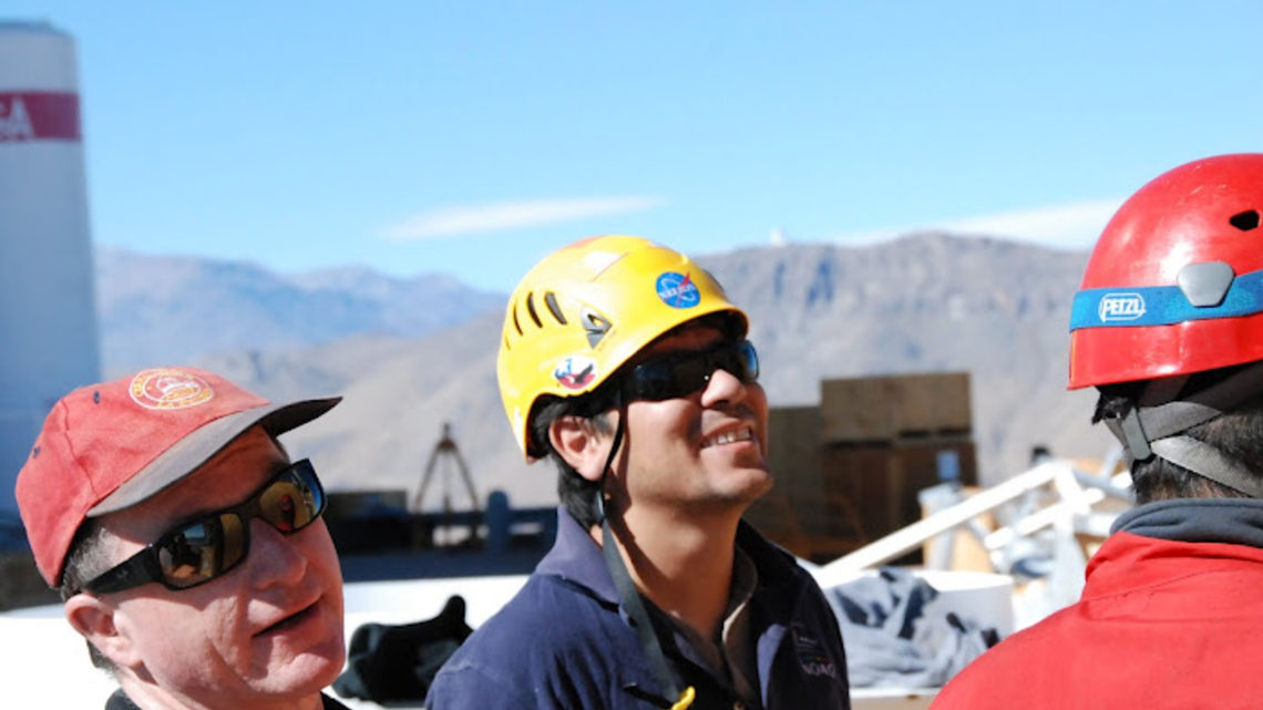 Fermilab physicist Tom Diehl (left) watches workers from the Cerro Tololo Inter-American Observatory unpack pieces of the DEC