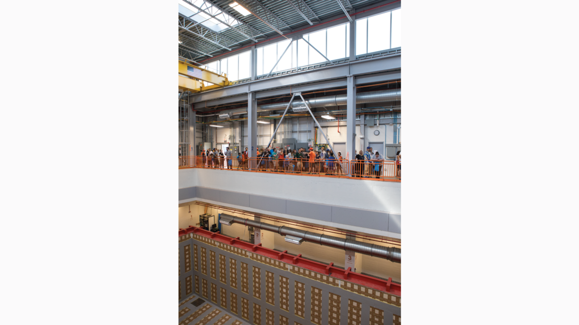 Visitors look down into the future home of the ICARUS detector, a neutrino hunter born in Italy that was recently refurbished at