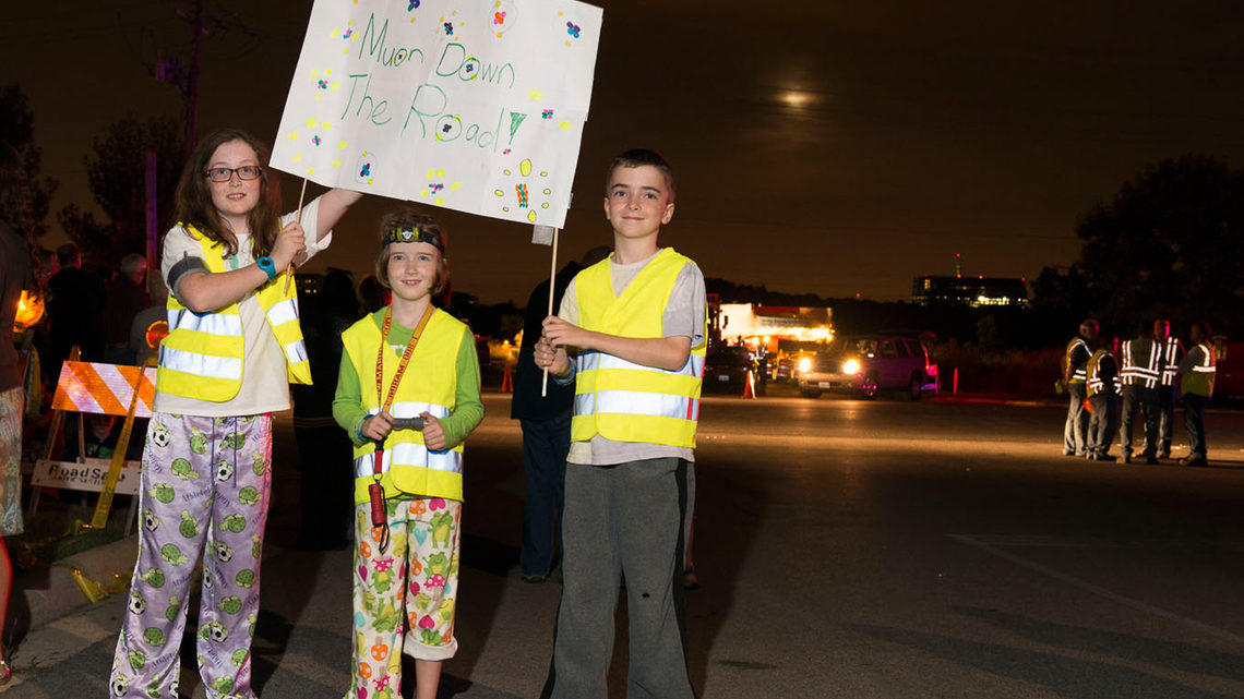 In their pajamas and safety vests, Maeve, Mary Kate and Kevin Pinkelman of Glen Ellyn, Illinois, cheered on the Muon g-2 ring