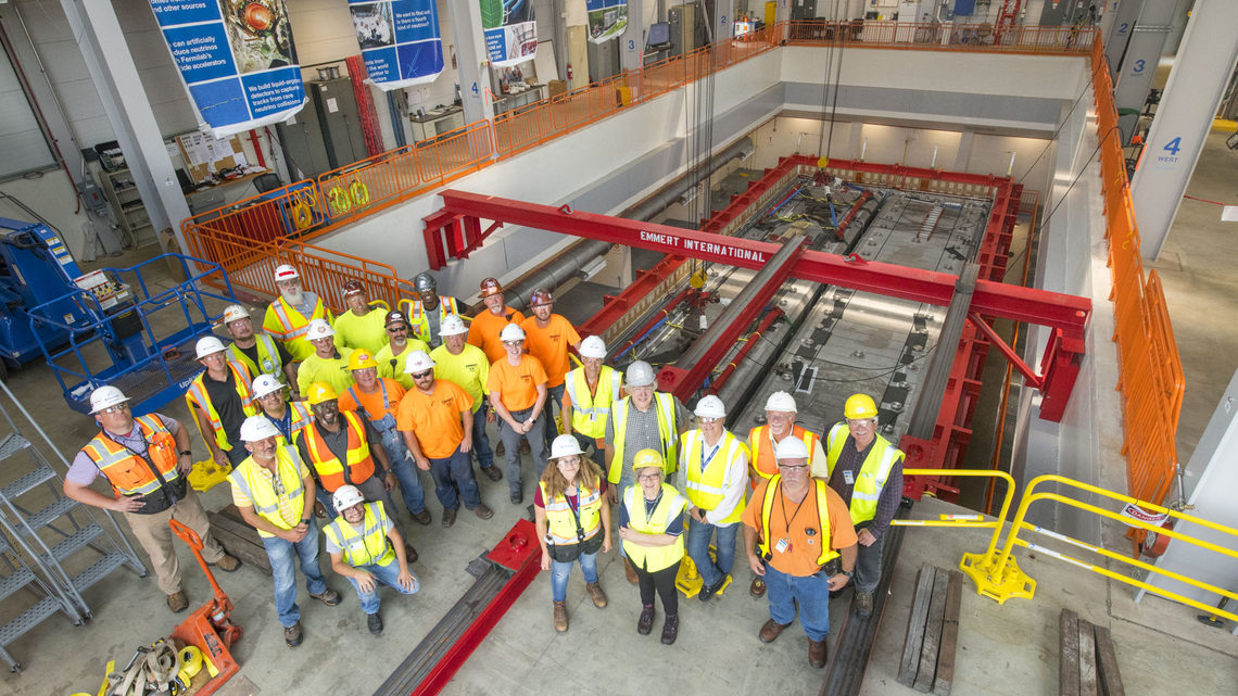Members of the team responsible for moving the ICARUS modules stand in front of the detector.