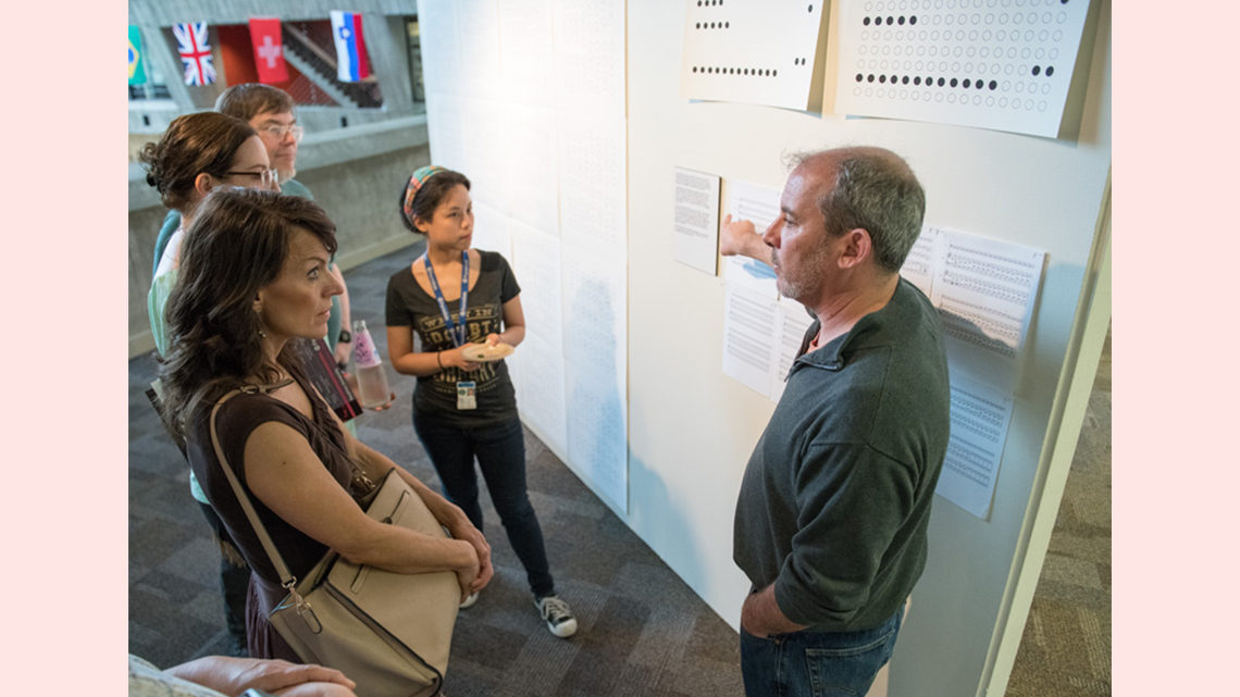 Nadel points to a display and addresses attendees