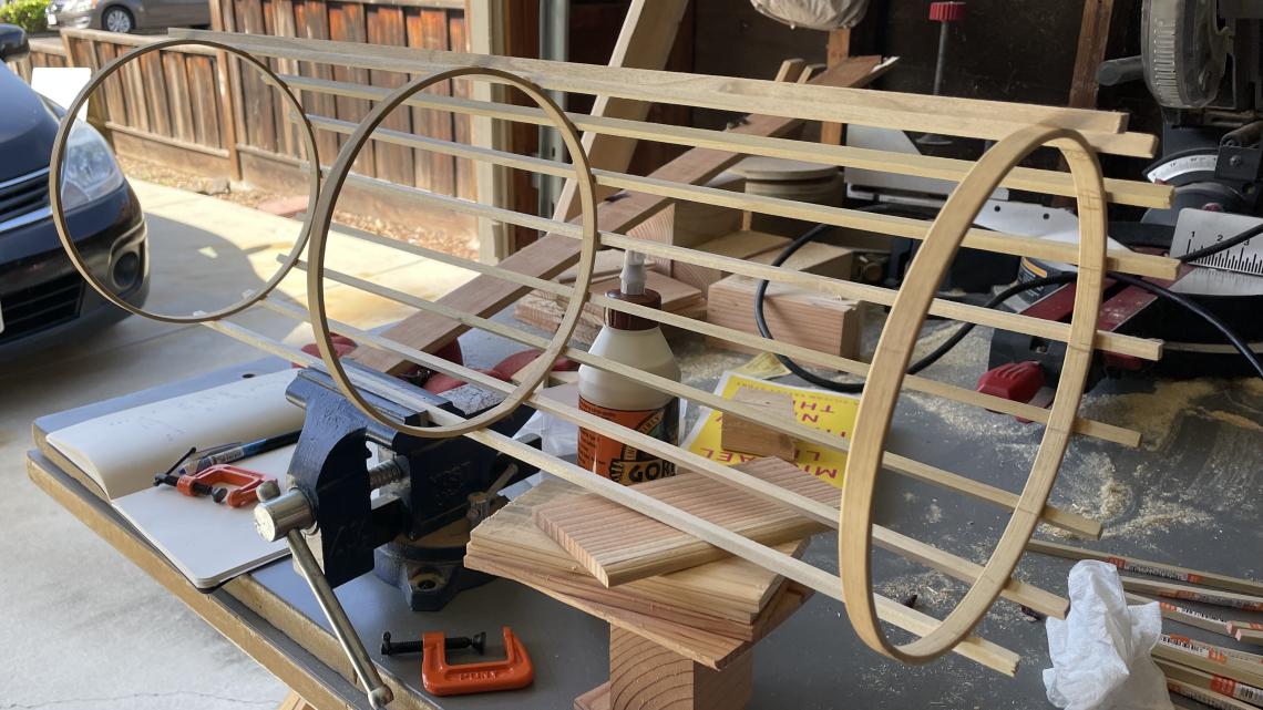 Photograph of the in-progress Disco-tracker, a cylinder made of three wooden circles connected by thin, straight wooden planks