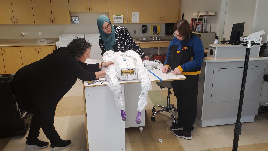 The team works together to finalize the protective clothing