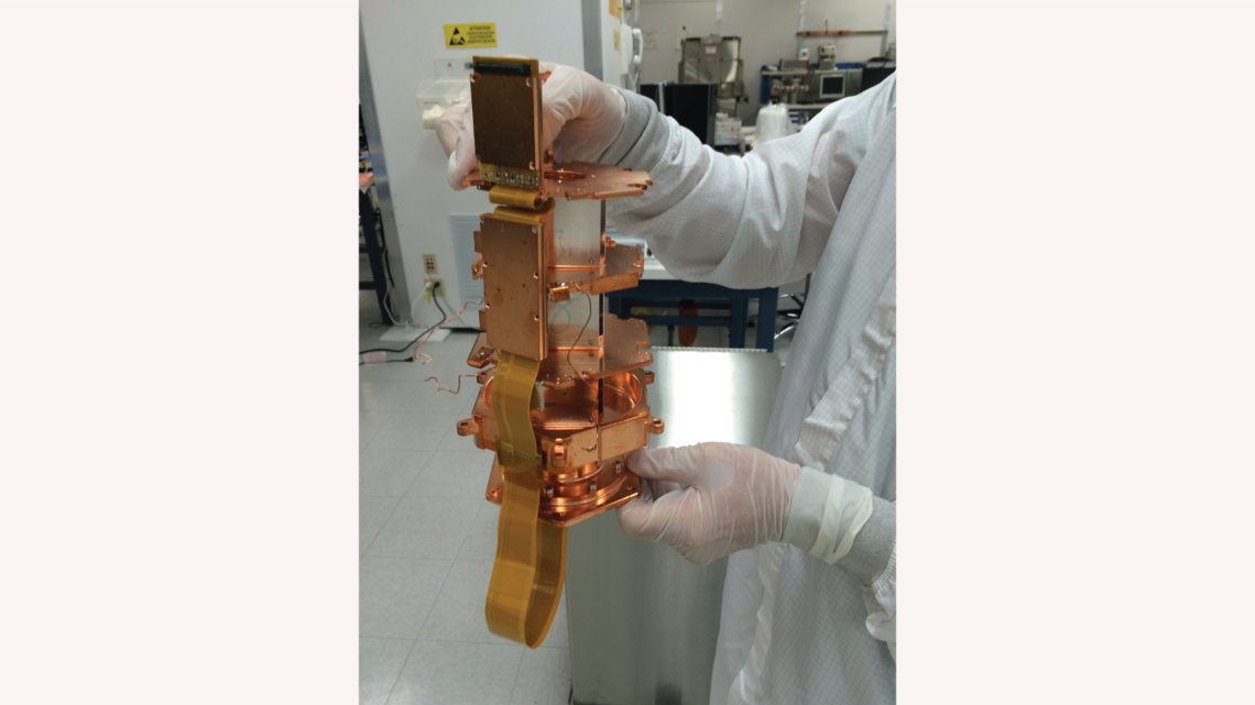 SLAC's Tsuguo Aramaki is inspecting an electrical readout section of the SuperCDMS SNOLAB engineering tower.