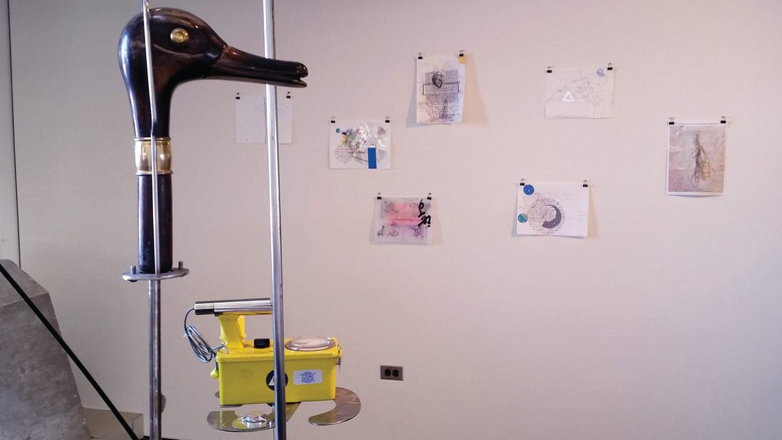 Photo in the foreground is a duck head handle of an umbrella used in Sitting Duck Soup, behind is a Geiger Counter