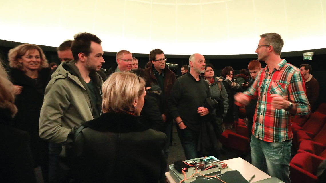 Photo of visitors approaching Van Hove, who is on the CMS experiment at the LHC, after the talk