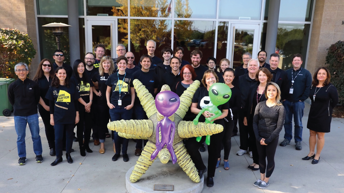 Photo of employees at SLAC National Accelerator Laboratory celebrating Dark Matter Day with Facebook Live broadcasts