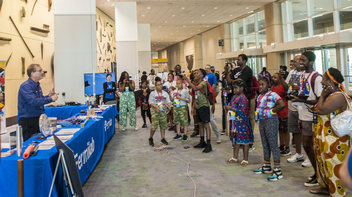 Wakandacon attendees watch a demonstration at the Fermilab booth