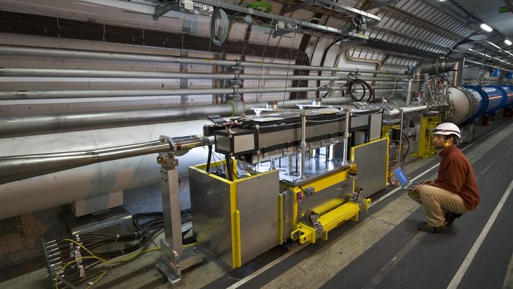 A technician next to the detector