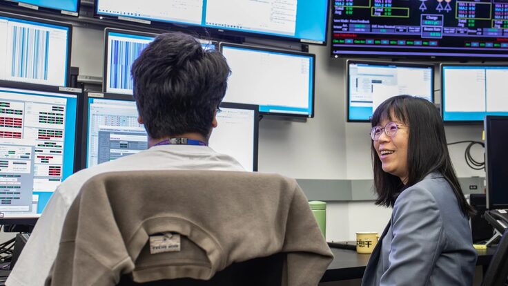 Wan-Lin Hu is seen talking with talks with accelerator systems operator Kabir Lubana in the lab’s main Accelerator Control Room. 