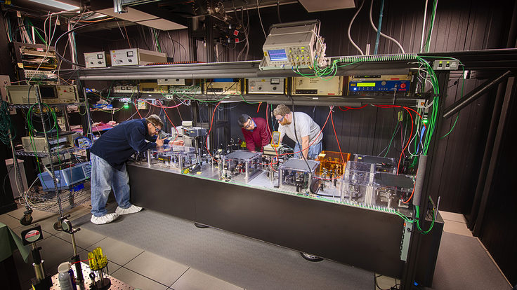 Scientists in laser safety goggles work in a laser lab