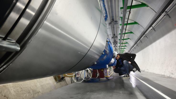 A technician inspect part of a particle detector