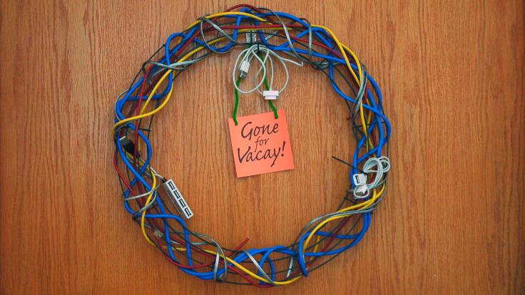 Wreath made of computer cables and post it note reading "Gone for Vacay"