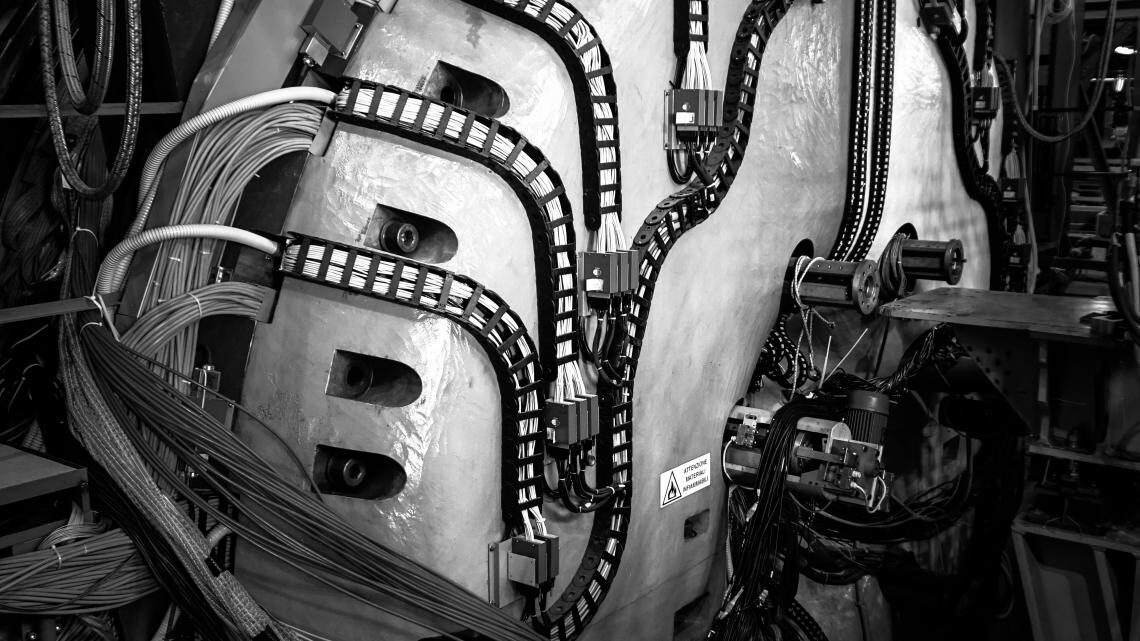 Black and white image of a round piece of equipment snaked with multiple sets of chords
