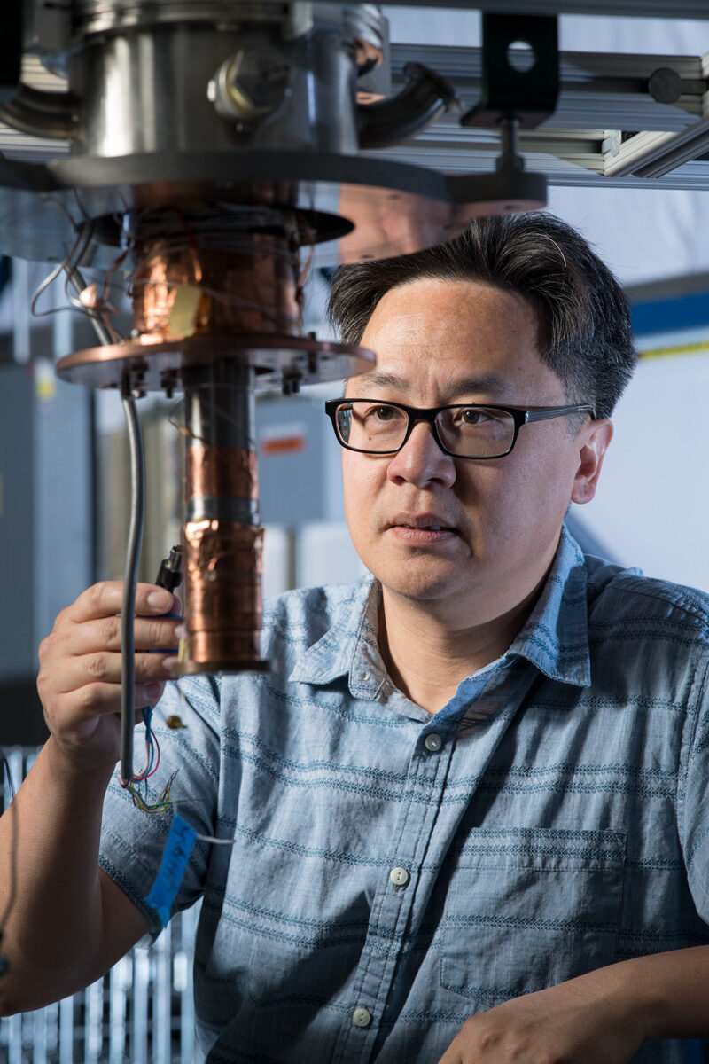Photo of a scientist connecting a wire to a piece of equipment